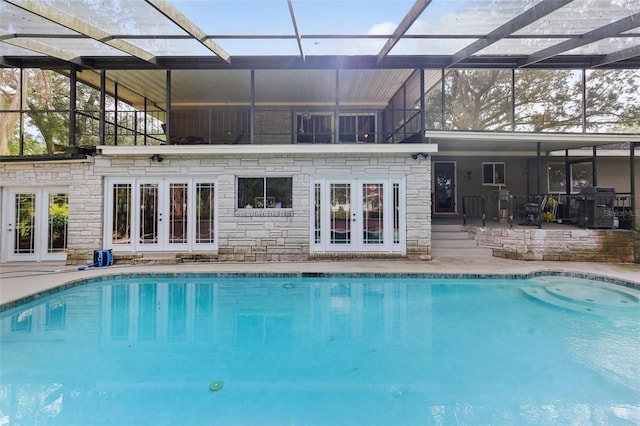 view of pool featuring french doors, a patio, and a lanai