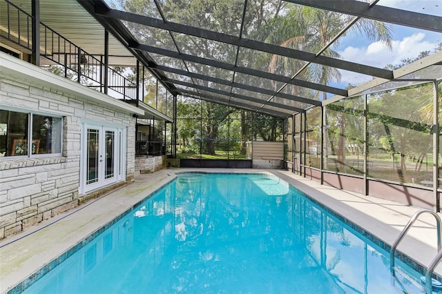 view of swimming pool with a lanai and french doors