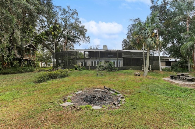 view of yard with a lanai and an outdoor fire pit