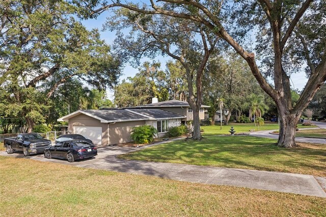 ranch-style home featuring a garage and a front lawn