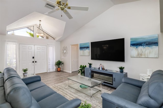 living room featuring light hardwood / wood-style flooring, ceiling fan, and lofted ceiling