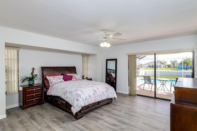 bedroom featuring hardwood / wood-style flooring, ceiling fan, a textured ceiling, and access to outside