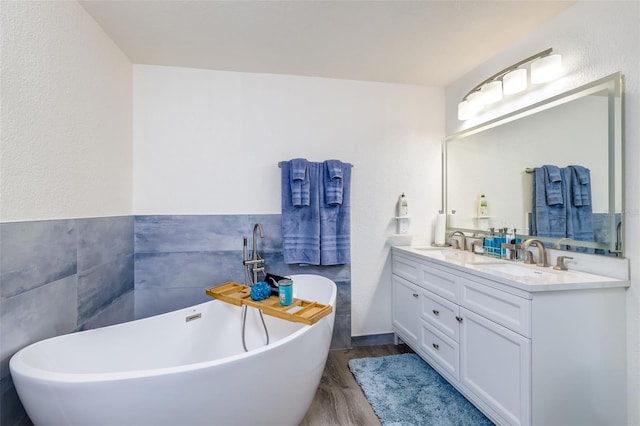 bathroom with a bathtub, vanity, and wood-type flooring