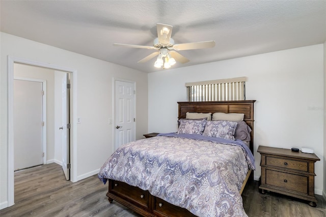 bedroom featuring ceiling fan, hardwood / wood-style floors, and a textured ceiling