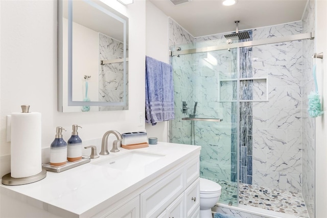 bathroom featuring vanity, toilet, and a shower with shower door