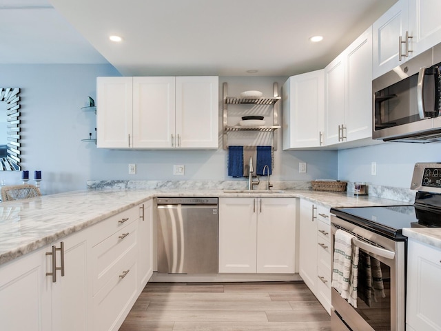 kitchen with white cabinets, appliances with stainless steel finishes, and sink