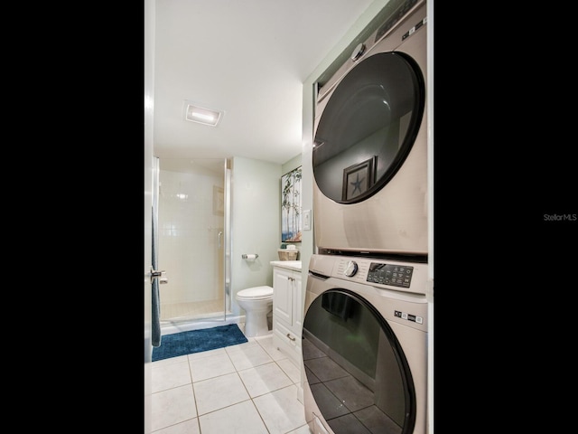 laundry room featuring light tile patterned flooring and stacked washer and clothes dryer