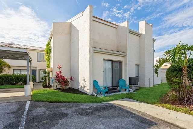 back of house with a lawn and central air condition unit