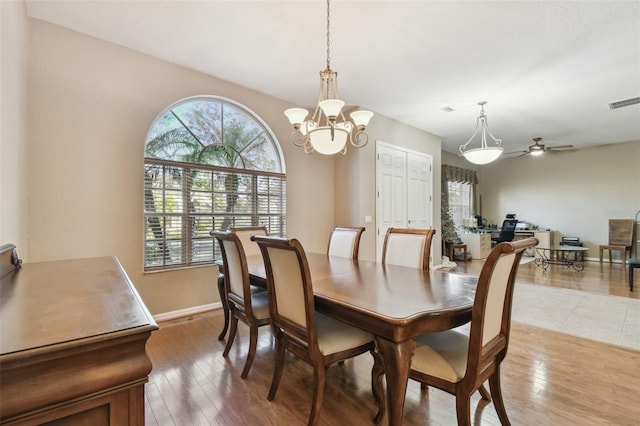 dining area featuring ceiling fan with notable chandelier and light hardwood / wood-style floors