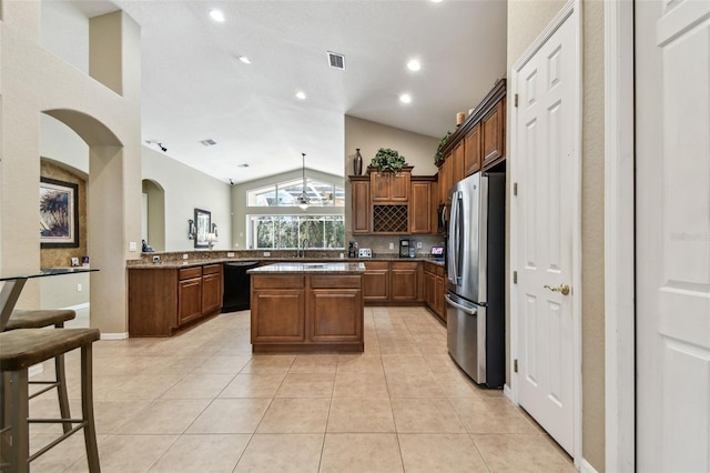 kitchen featuring a center island, lofted ceiling, stainless steel fridge, black dishwasher, and kitchen peninsula