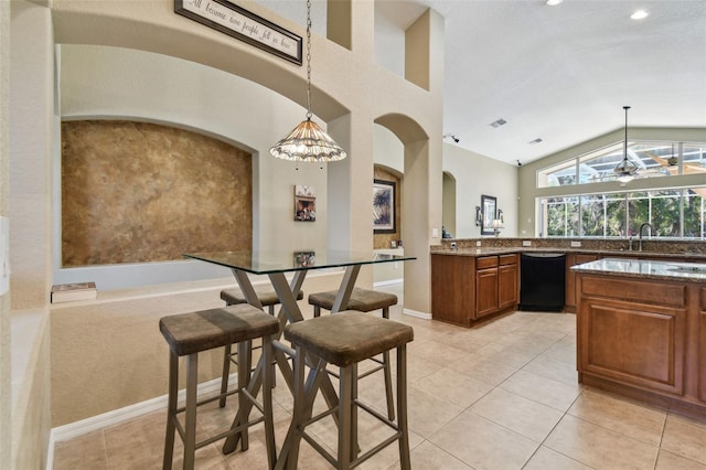 kitchen with stone counters, dishwasher, ceiling fan, and hanging light fixtures