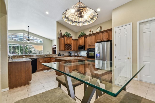 kitchen with a notable chandelier, decorative light fixtures, vaulted ceiling, light tile patterned floors, and black appliances