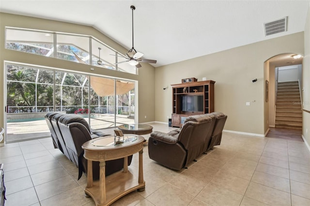 tiled living room with ceiling fan and lofted ceiling