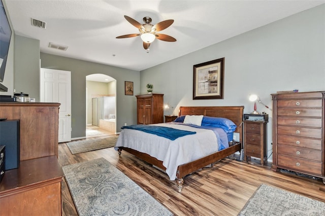 bedroom with ceiling fan, light hardwood / wood-style floors, and ensuite bath