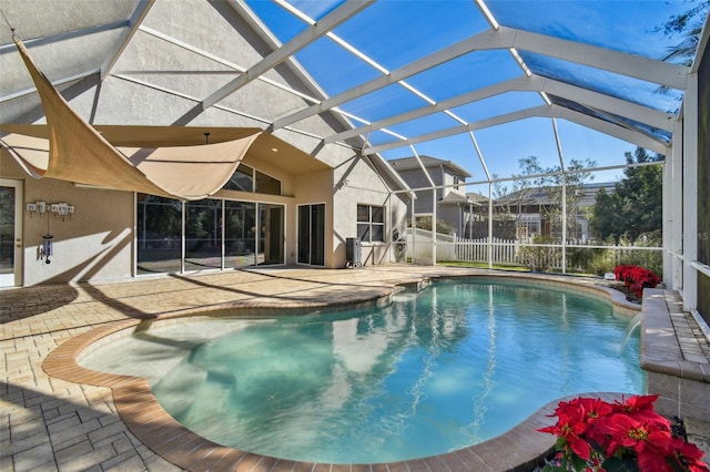 view of swimming pool with pool water feature, a patio area, and a lanai