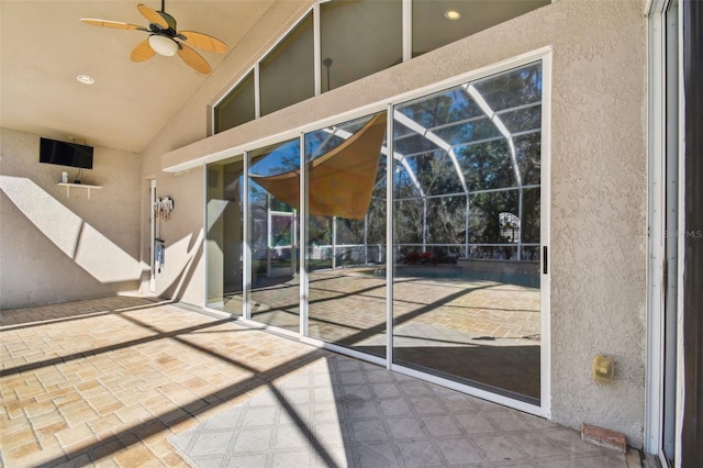 doorway to property with ceiling fan and a patio area