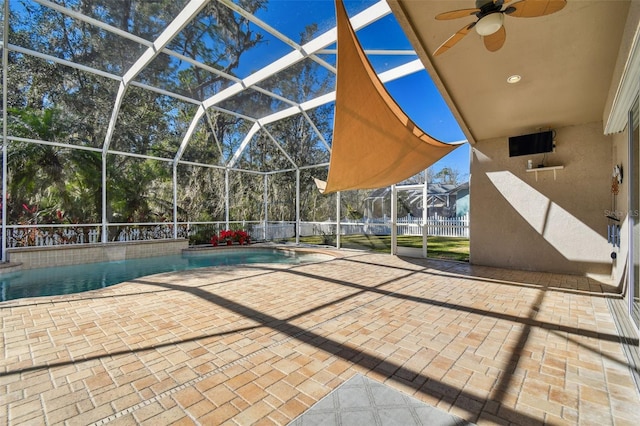 view of patio / terrace featuring a fenced in pool, glass enclosure, and ceiling fan