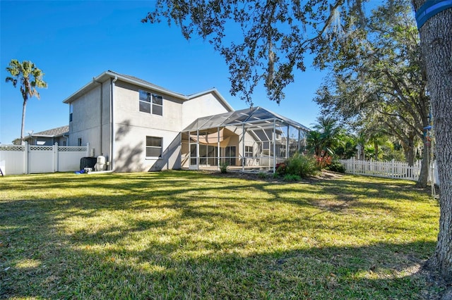 back of property featuring a lawn and glass enclosure