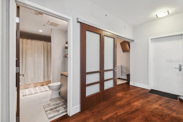 corridor with dark hardwood / wood-style flooring and french doors