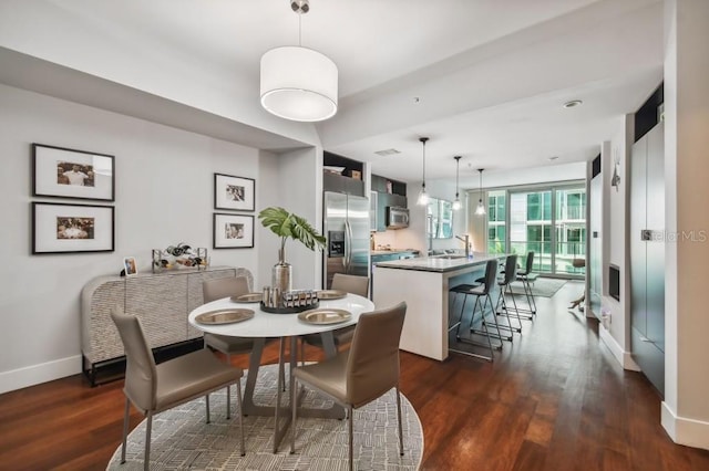 dining area with sink and dark wood-type flooring