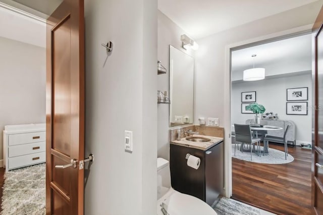 bathroom with vanity, toilet, and wood-type flooring