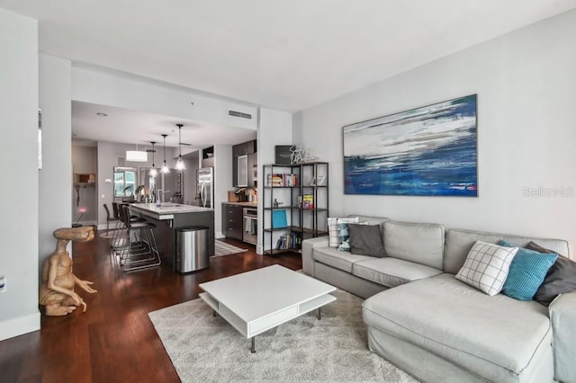 living room with dark hardwood / wood-style flooring and sink