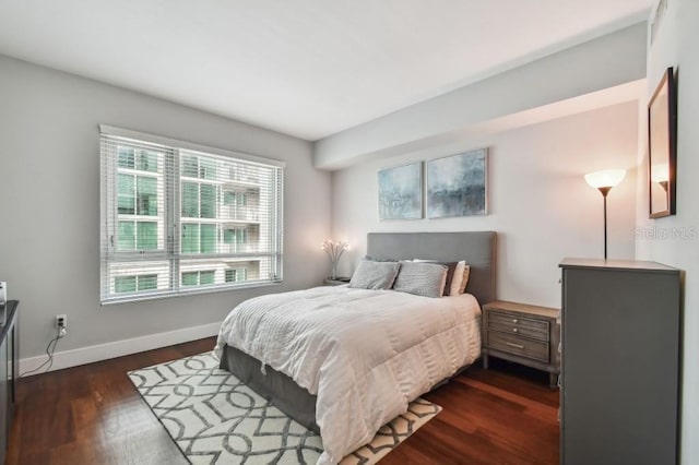 bedroom featuring multiple windows and dark hardwood / wood-style floors