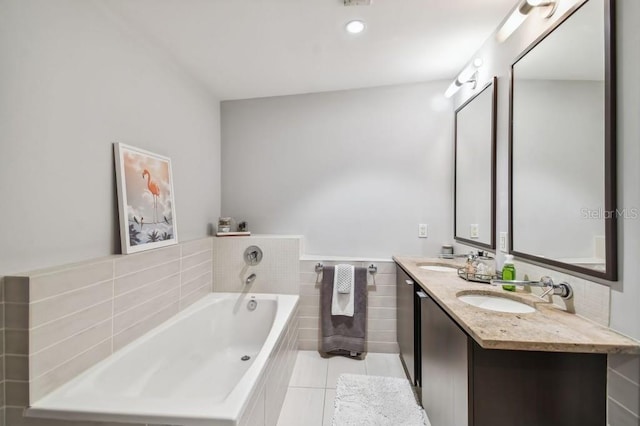 bathroom with tile patterned flooring, vanity, and a bath