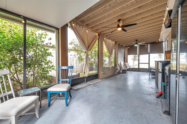 unfurnished sunroom with ceiling fan