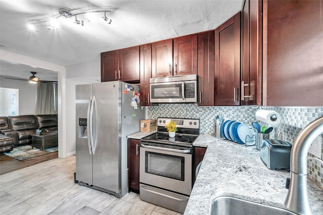 kitchen with tasteful backsplash, ceiling fan, sink, appliances with stainless steel finishes, and a textured ceiling