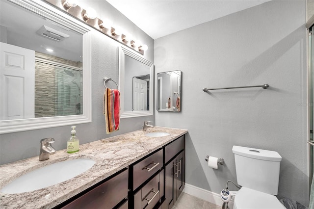 bathroom with tile patterned floors, an enclosed shower, vanity, and toilet