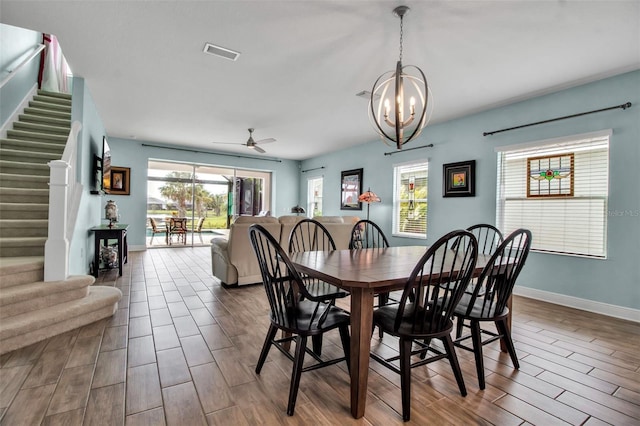 dining room featuring ceiling fan with notable chandelier