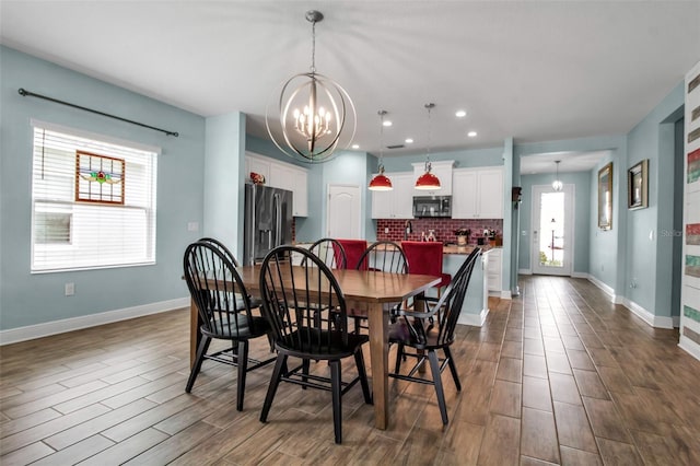 dining room with dark wood-type flooring and a chandelier