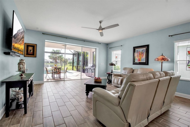 living room featuring ceiling fan and a wealth of natural light