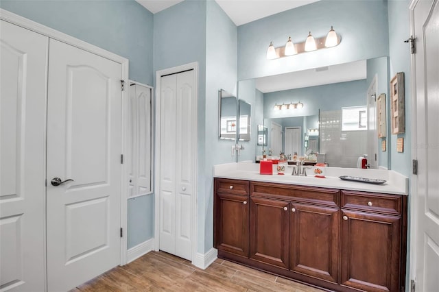 bathroom featuring walk in shower, wood-type flooring, and vanity