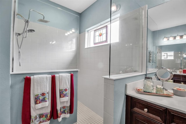 bathroom with vanity and a tile shower