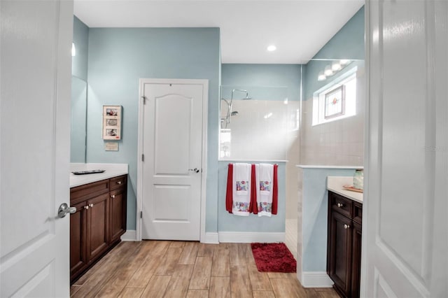 bathroom with vanity, hardwood / wood-style floors, and a tile shower