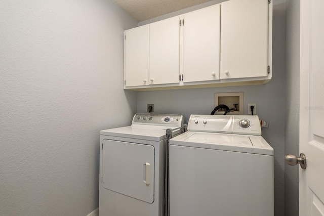 washroom featuring cabinets, a textured ceiling, and independent washer and dryer