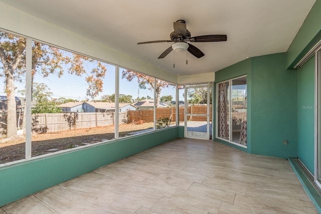 unfurnished sunroom with ceiling fan