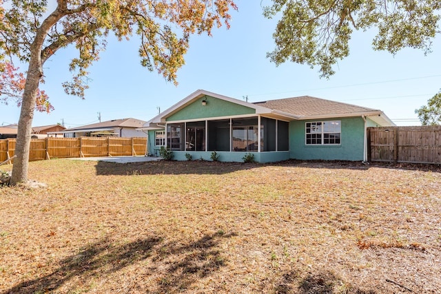 back of property featuring a sunroom and a yard