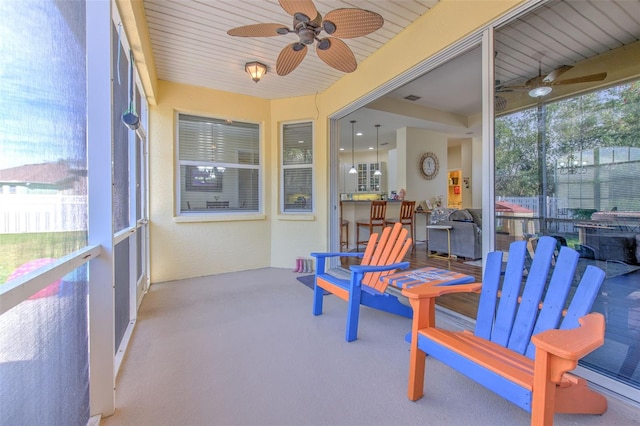 sunroom featuring ceiling fan and wooden ceiling