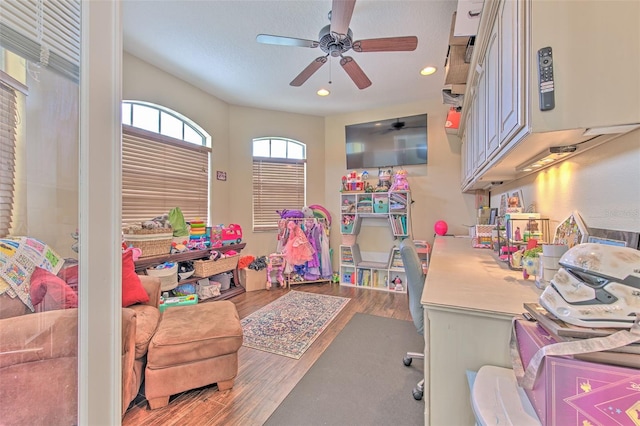 playroom with ceiling fan and wood-type flooring