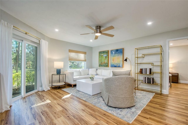 living room with ceiling fan and light hardwood / wood-style flooring