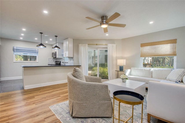 living room featuring light wood-type flooring and ceiling fan