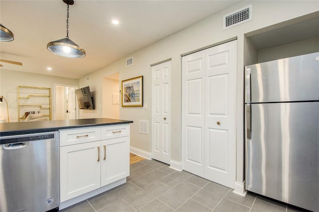 kitchen with white cabinets, appliances with stainless steel finishes, tile patterned flooring, and pendant lighting