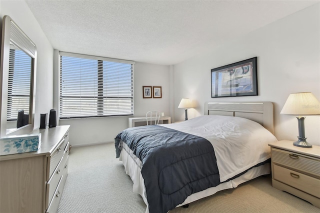 bedroom with light carpet and a textured ceiling