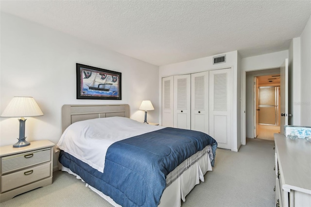 carpeted bedroom with a textured ceiling and a closet