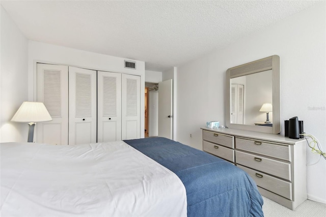 carpeted bedroom with a textured ceiling and a closet