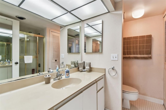 bathroom with tile patterned flooring, vanity, toilet, and walk in shower