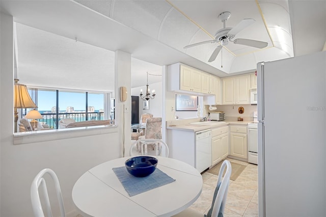 tiled dining room with ceiling fan with notable chandelier